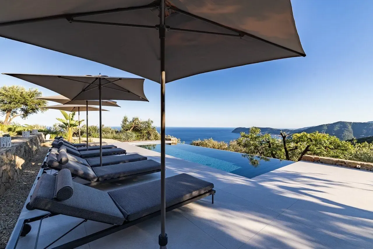 Sunbeds and parasols along the infinity pool facing the bay