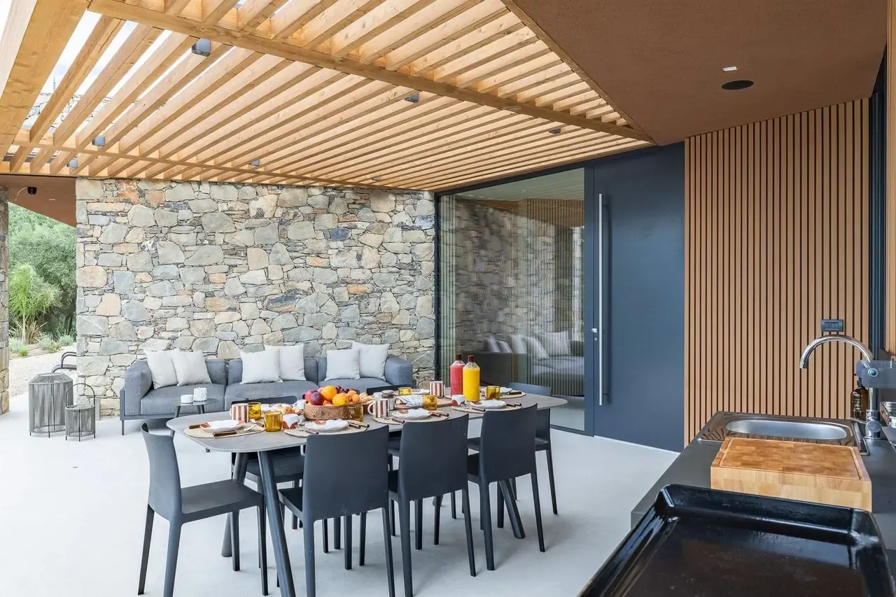 Patio dining table laid for breakfast beside the outdoor kitchen