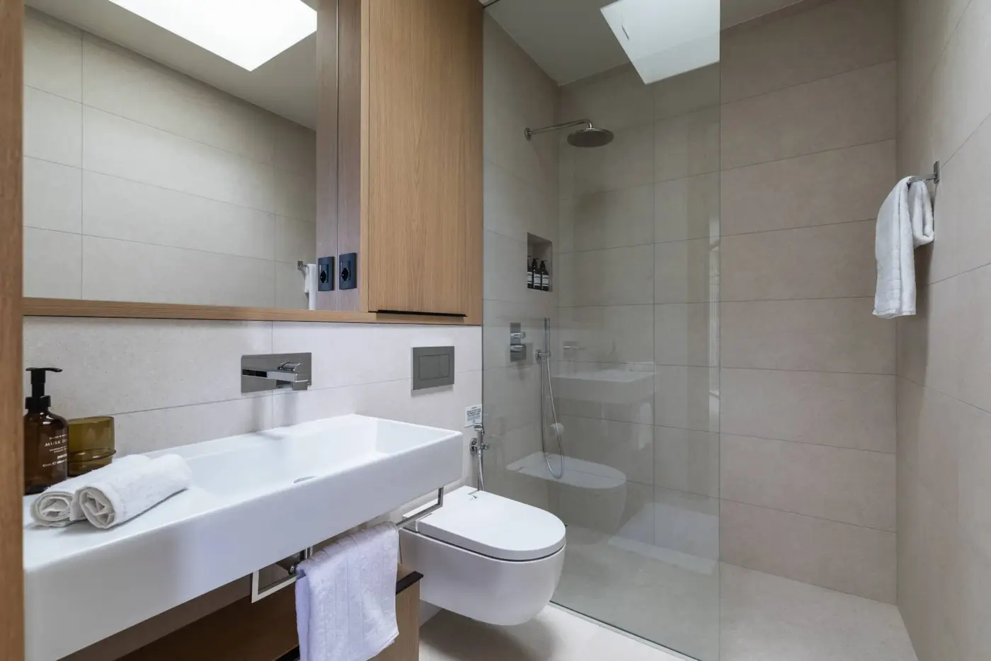 Bagno della suite con doccia walk-in, lucernari apribili e mobile in rovere